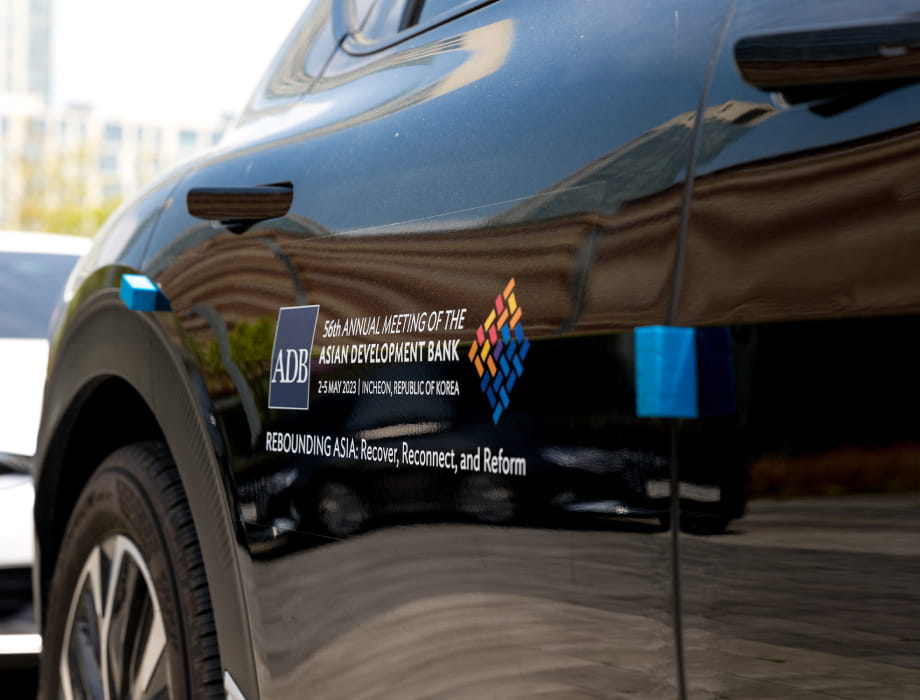 ADB logo and information about the 56th Annual Meeting displayed on the side door of a vehicle.