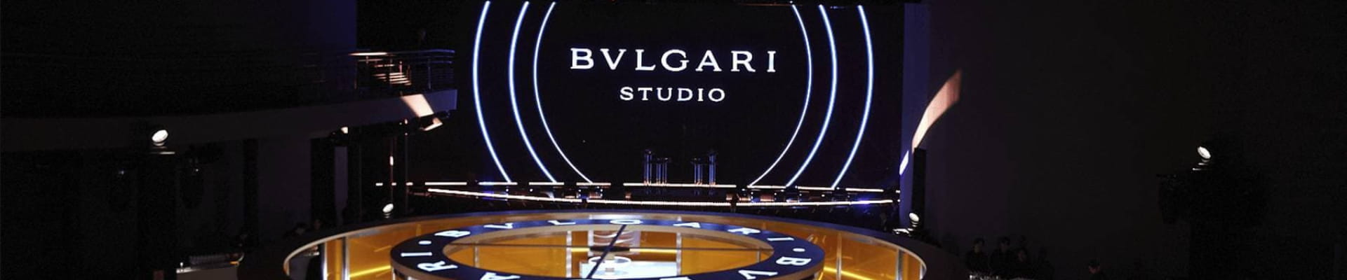 Bvlgari Studio stage setup with illuminated circular platform and large screen displaying the Bvlgari logo.