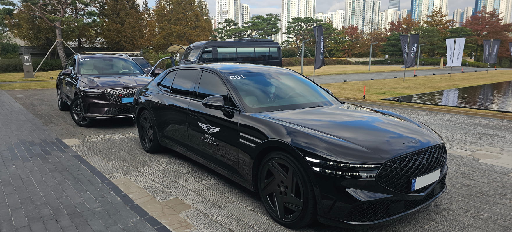 Black Genesis G90 sedan and GV80 SUV prepared for premium VIP transport service at the 2024 Genesis Championship site.