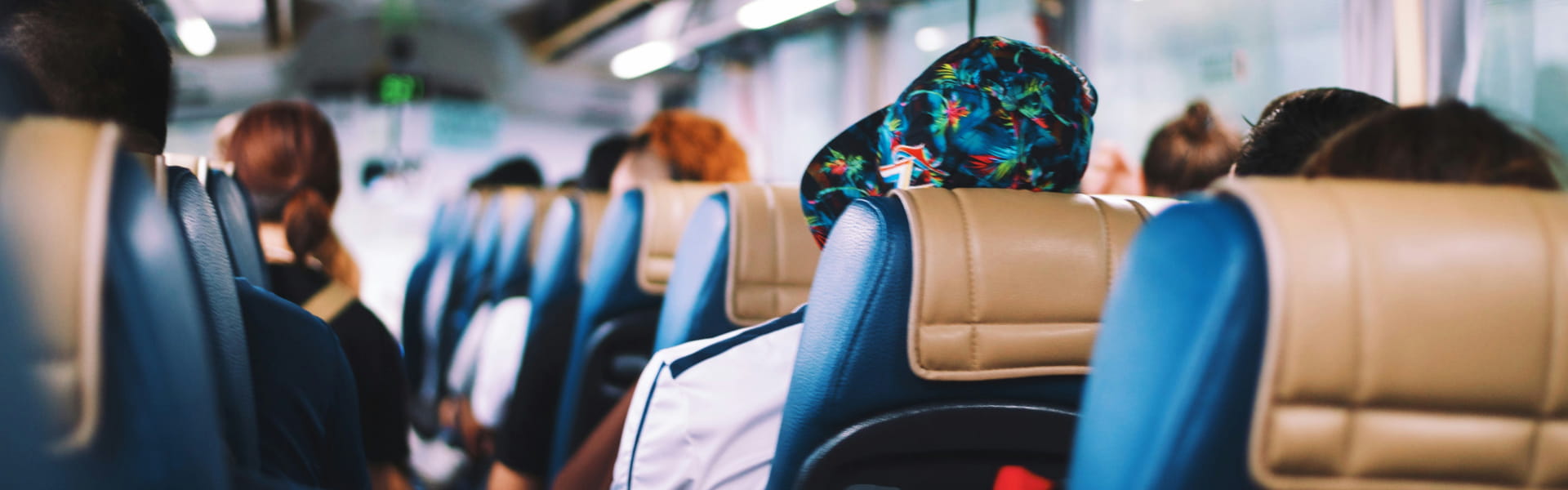 Back view of people seated on an airport shuttle bus.